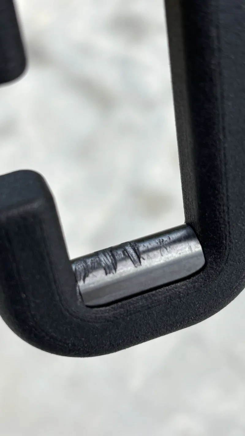 Close-up of a bicycle chain roller pin after a first application of CHA Core on a new chain.